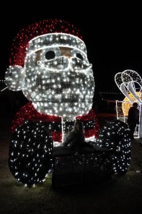A little girl takes her picture with Santa light at Luminance Dec. 8. Photo By Heather Moery