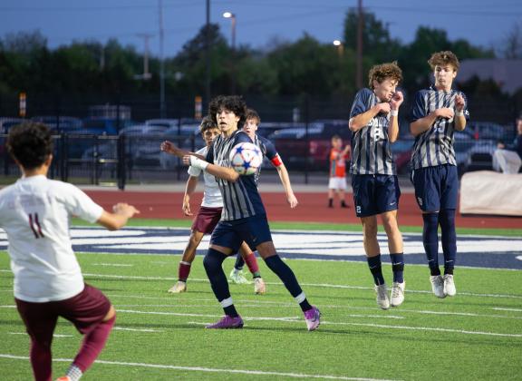 Edmond North players, from left, Maximo Elizondo Caldera, Adam Froehlich and Wylie Smith defend a Capitol Hill kick Friday night. Photo by Drew Harmon.