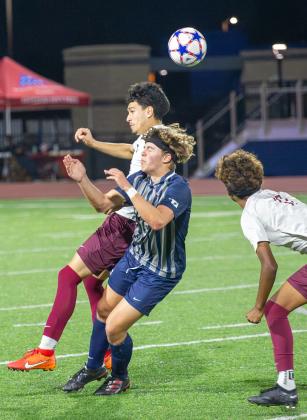 Edmond North’s Asher Pickard and a Capitol Hill defender try to head the ball Friday night. Photo by Drew Harmon