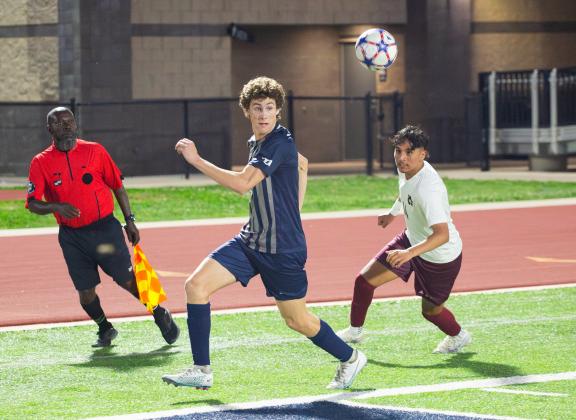 Edmond North’s Corban Mullins centers the ball in front of the Capitol Hill goal Friday night. Photo by Drew Harmon.