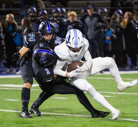 Deer Creek defenders Jaydon Bradshaw (1) and Garrison Farr (34) make a stop in the win over Bartlesville on Friday night. Photo by Drew Harmon.