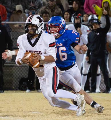 Oklahoma Christian School's (76) closes in on the Meeker quarterback during the Saints' first-round playoff loss on Friday night. Photo by Drew Harmon.