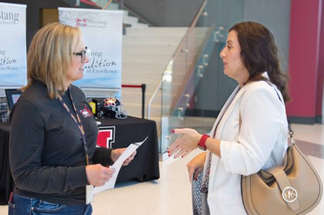 Meagan Cole (right) gives her resume to Human Resources Specialist Cheryl Rodgers at the Mustang Public Schools job fair April 11, 2024. (Ted StreuliOklahoma Watch)