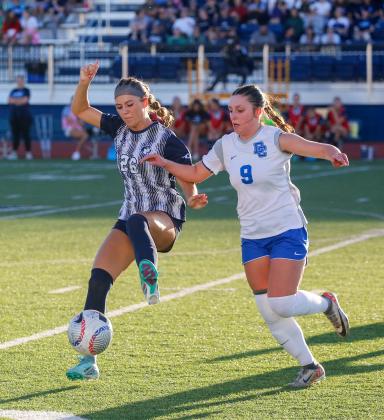 Edmond North’s Makenna Meyers controls the ball as Deer Creek’s Macey McFarland closes in Tuesday evening in the second round of the Class 6A playoffs. Photo by Drew Harmon.