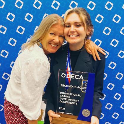 Francis Tuttle student Ayla Relland accepts the second place award for Community Awareness Project with her Business Marketing and Management instructor Natalie Jordan at the 2024 DECA International Career Development Conference in Anaheim, Calif.